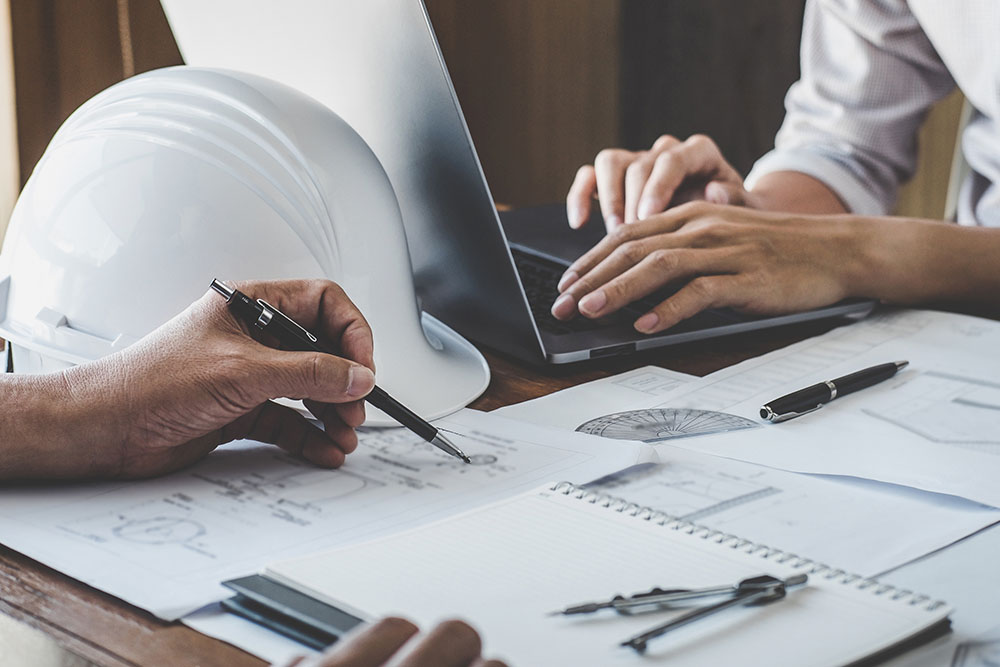 Engineer Working Drawing on Blueprint | Maven Group Investment Strategies
